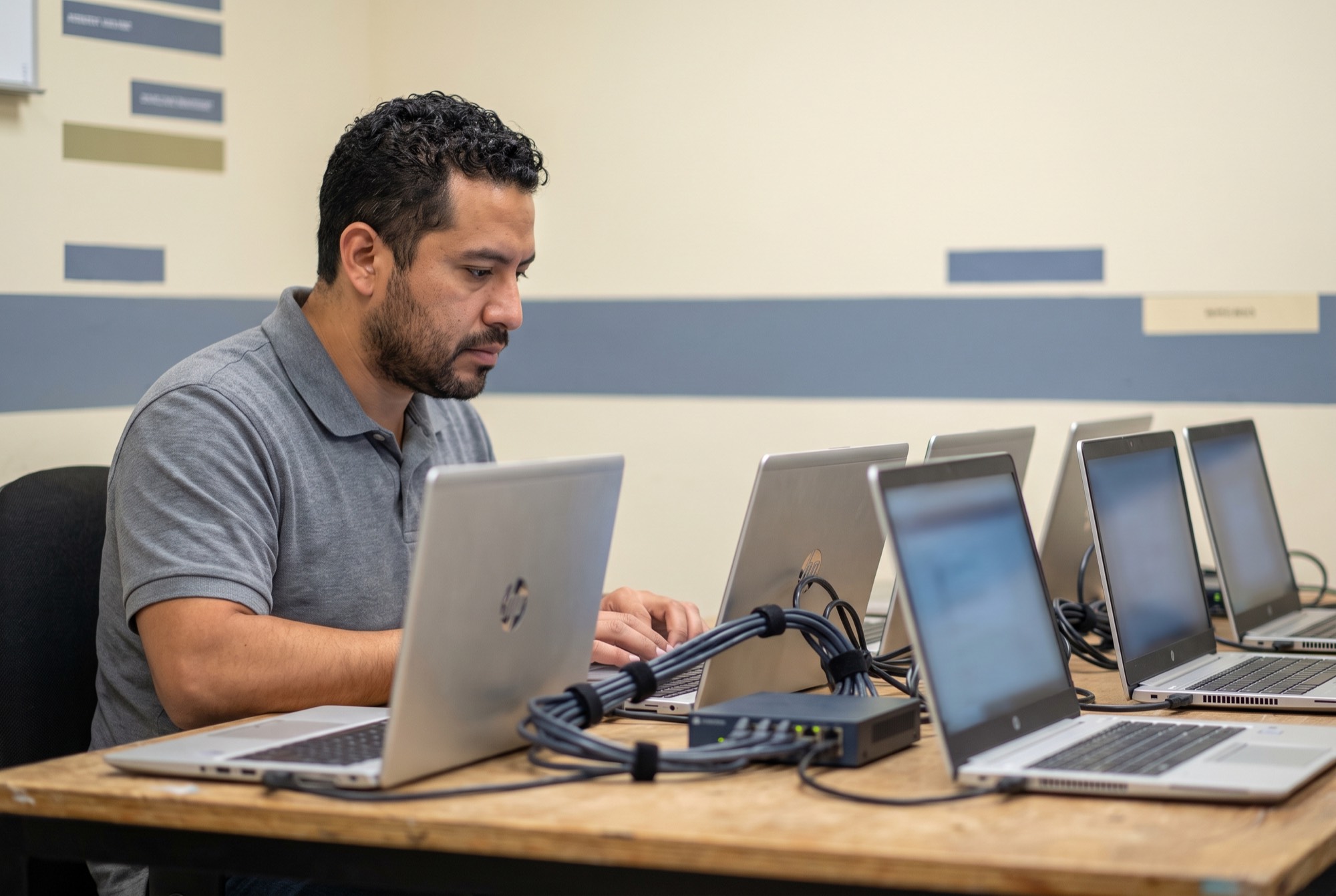 Técnico configurando laptops en serie conectadas a un switch de red